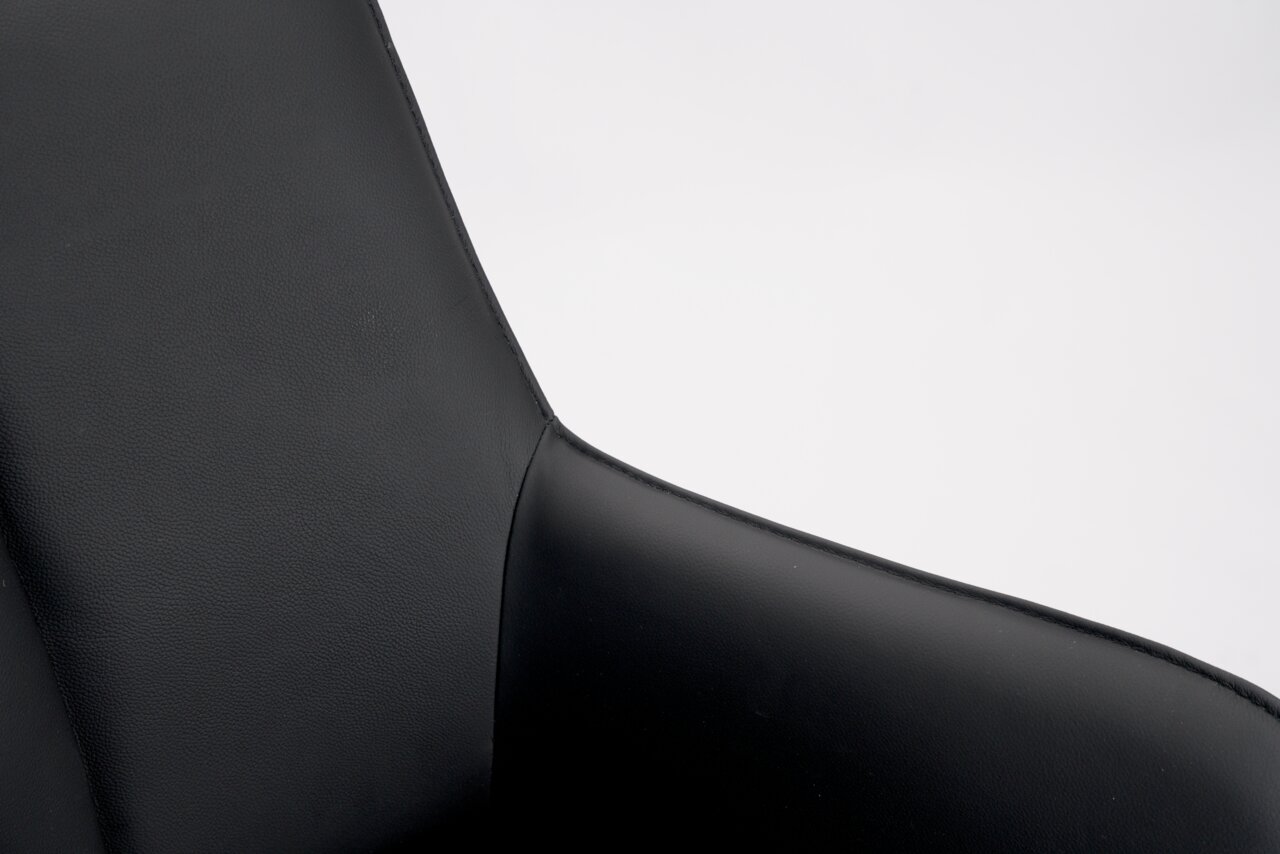 Nahaufnahme eines schwarzen Barhockers aus Leder, Fokus auf die Rückenlehne.