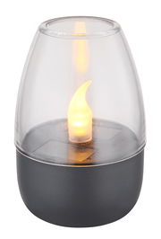 Nahaufnahme einer Solarleuchte mit flammenförmigem LED-Licht in einem transparenten Gehäuse auf einem dunklen Sockel.