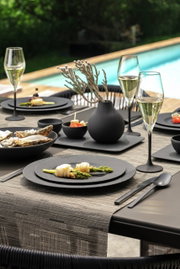 Een elegante set champagneglazen op een stijlvol gedekte tafel, met op de achtergrond uitzicht op een zwembad.