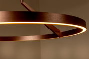 Moderne runde LED-Pendelleuchte in Kupferoptik mit warmweißem Licht, Detailaufnahme aus leicht seitlicher Untersicht
