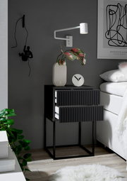 Moderne Nachtkommode mit zwei Schubladen in dunklem Design, seitliche Perspektive, dekoriert mit einer Vase und einer Uhr.