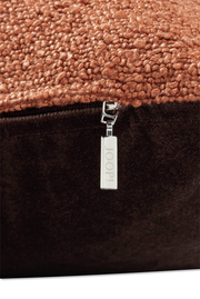 Nahaufnahme einer Zierkissenhülle mit grober Textur und einem Reißverschluss mit der Aufschrift 'JOOP!'