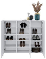 Moderner weißer Hängeschuhschrank mit offenen Türen, gefüllt mit verschiedenen Schuhen und dekorativen Elementen auf der Oberseite, Frontalansicht.