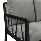 Nahaufnahme einer Gartenbank mit grauen Kissen und schwarzem Metallrahmen, seitliche Perspektive