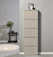 Hoher, schmaler Schuhschrank in Beige mit fünf Klappfächern, frontal aus leicht seitlicher Perspektive vor grauer Wand; oben Deko mit Bild und Schale, daneben Beistelltisch mit Vase.