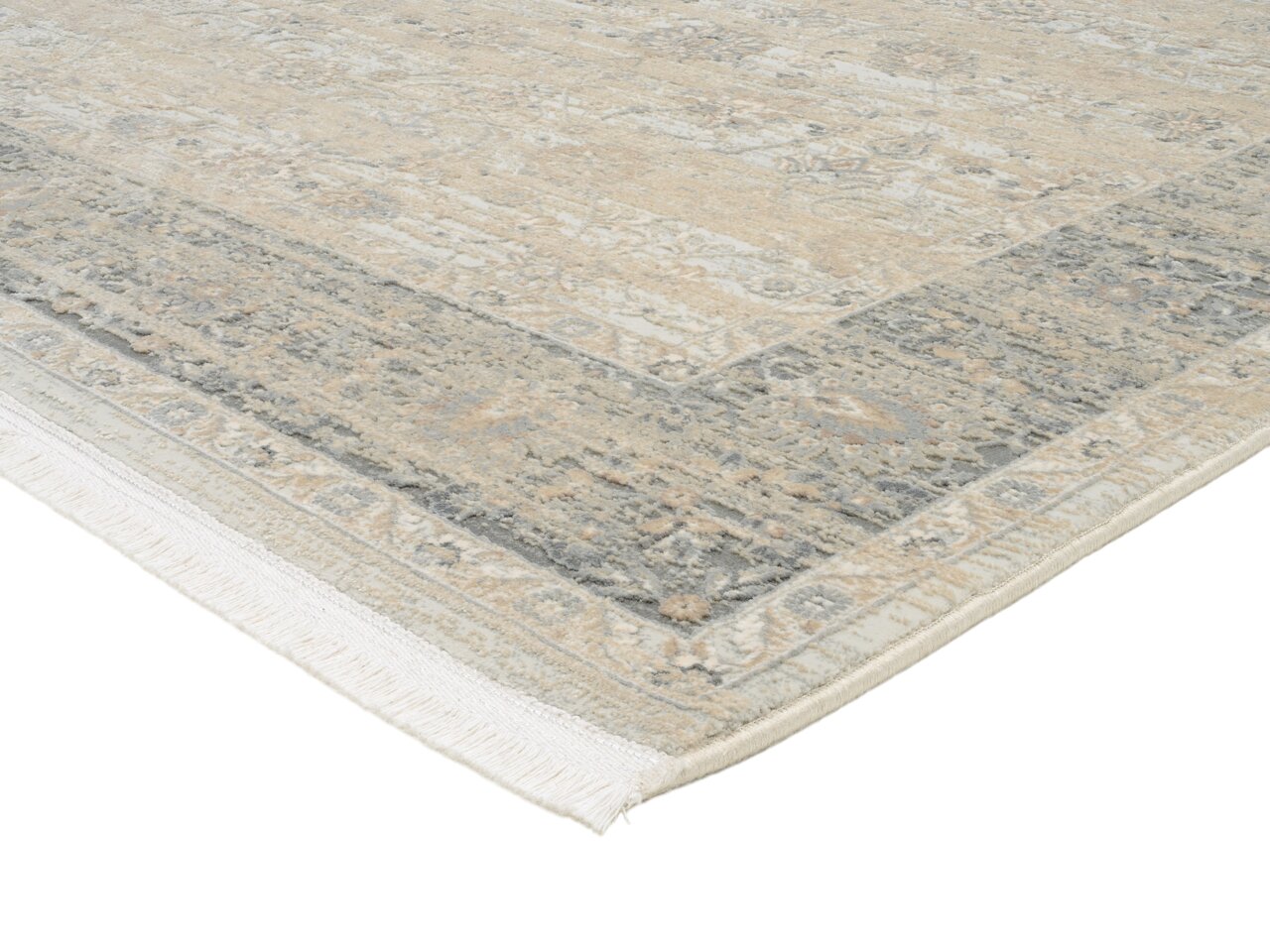 Designer Teppich in Beige- und Grautönen mit Fransen, perspektivisch von der Ecke aufgenommen.