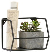 Wandregal NORA aus schwarzem Metall mit einer gerollten Karte und einem kleinen Pflanzentopf, seitliche Perspektive