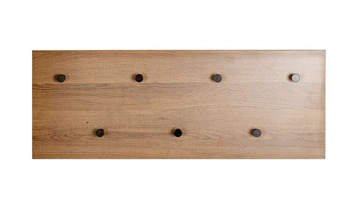 Rechteckige Wandgarderobe aus Holz mit natürlicher Maserung und sechs runden schwarzen Haken, frontal von vorne auf weißem Hintergrund fotografiert