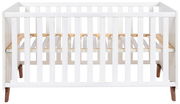 Weißes Babybett aus Holz, Vorderansicht mit Gitterstäben und erhöhtem Lattenrost.