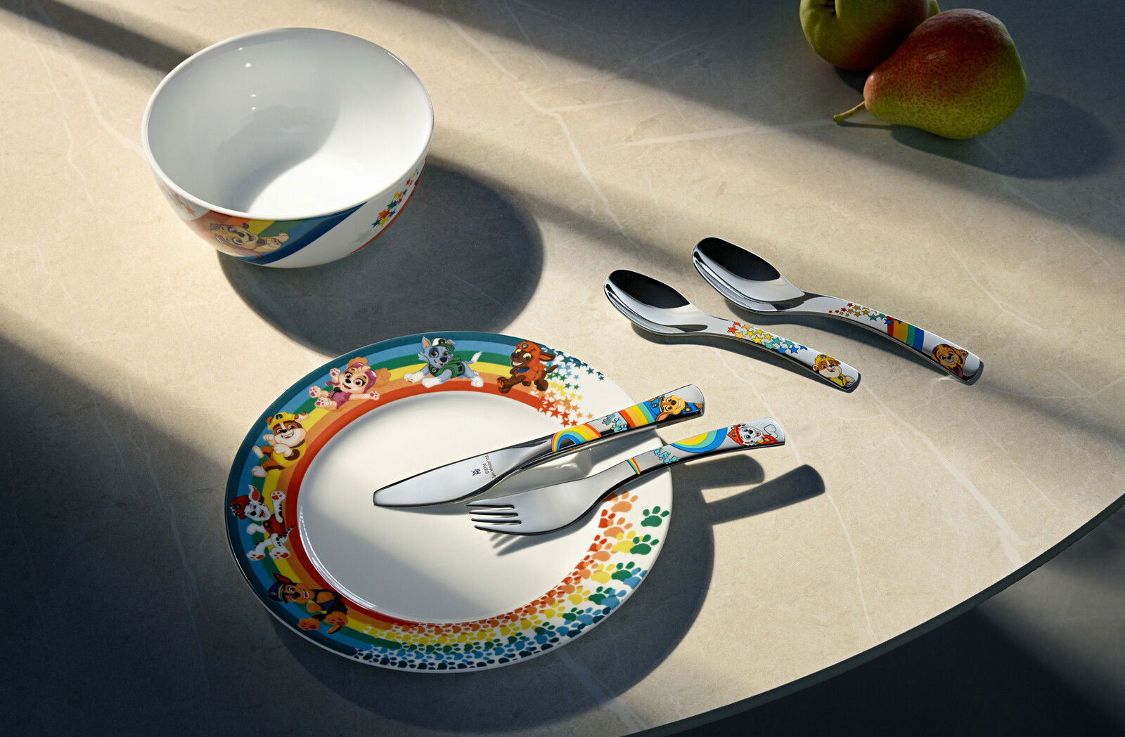 Paw Patrol Kinderset bestehend aus einem Teller, einer Schüssel und Besteck mit bunten Paw Patrol Motiven, von oben fotografiert.