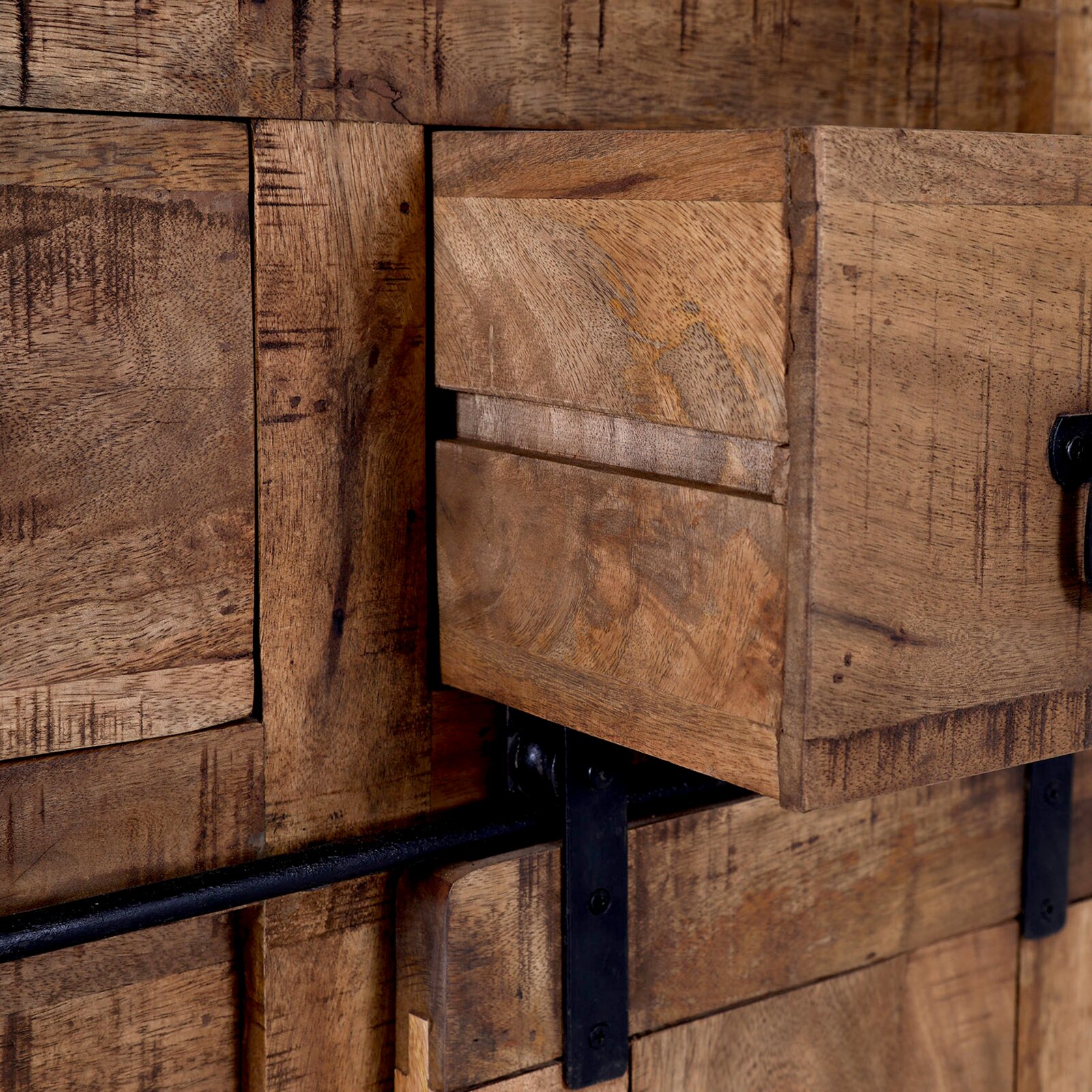 Close-up van een rustiek houten secretaire met geopende lade en metalen handgreep, gezien vanaf de zijkant.