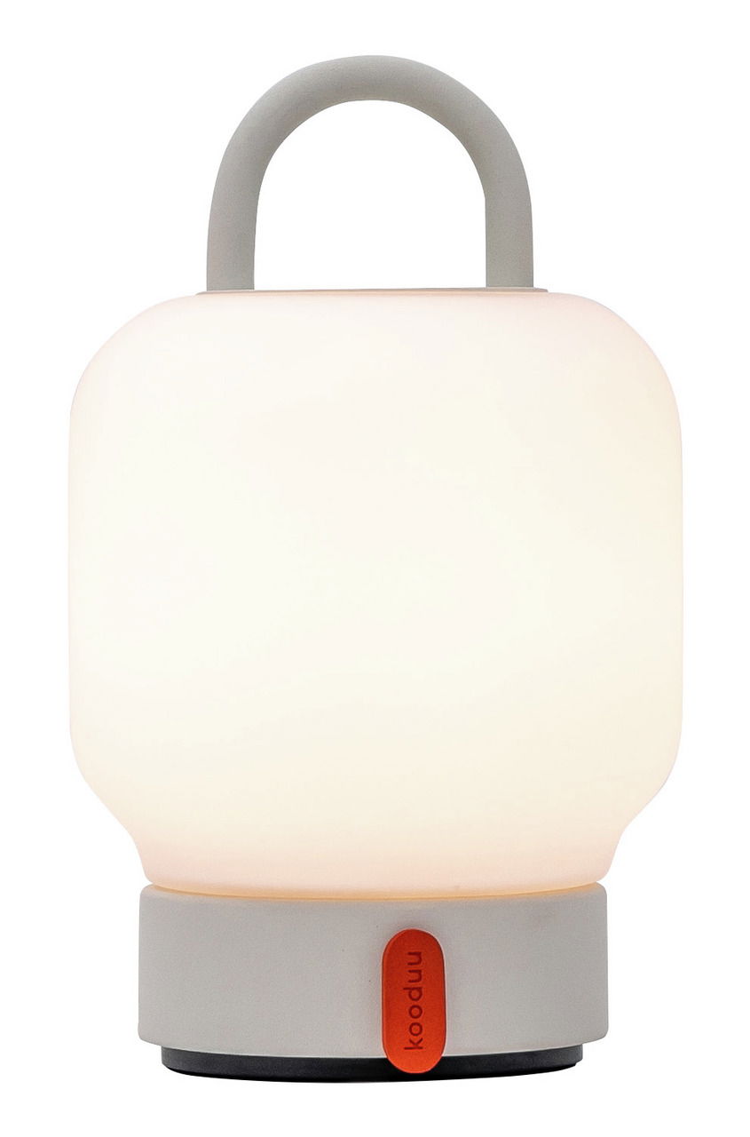 Tragbare weiße Lampe mit Griff, frontal abgebildet, auf einem grauen Sockel mit rotem Akzent.