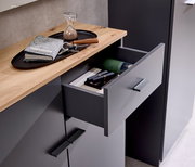 Kompaktgarderobe mit geöffneter Schublade, Holzoberfläche und modernen Griffen, aus der Vogelperspektive fotografiert.