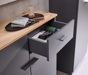 Kompaktgarderobe mit geöffneter Schublade, Holzoberfläche und modernen Griffen, aus der Vogelperspektive fotografiert.