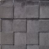 Nahaufnahme eines grauen, geflochtenen Stoffmusters eines Hockers mit Stauraum, von vorne betrachtet.