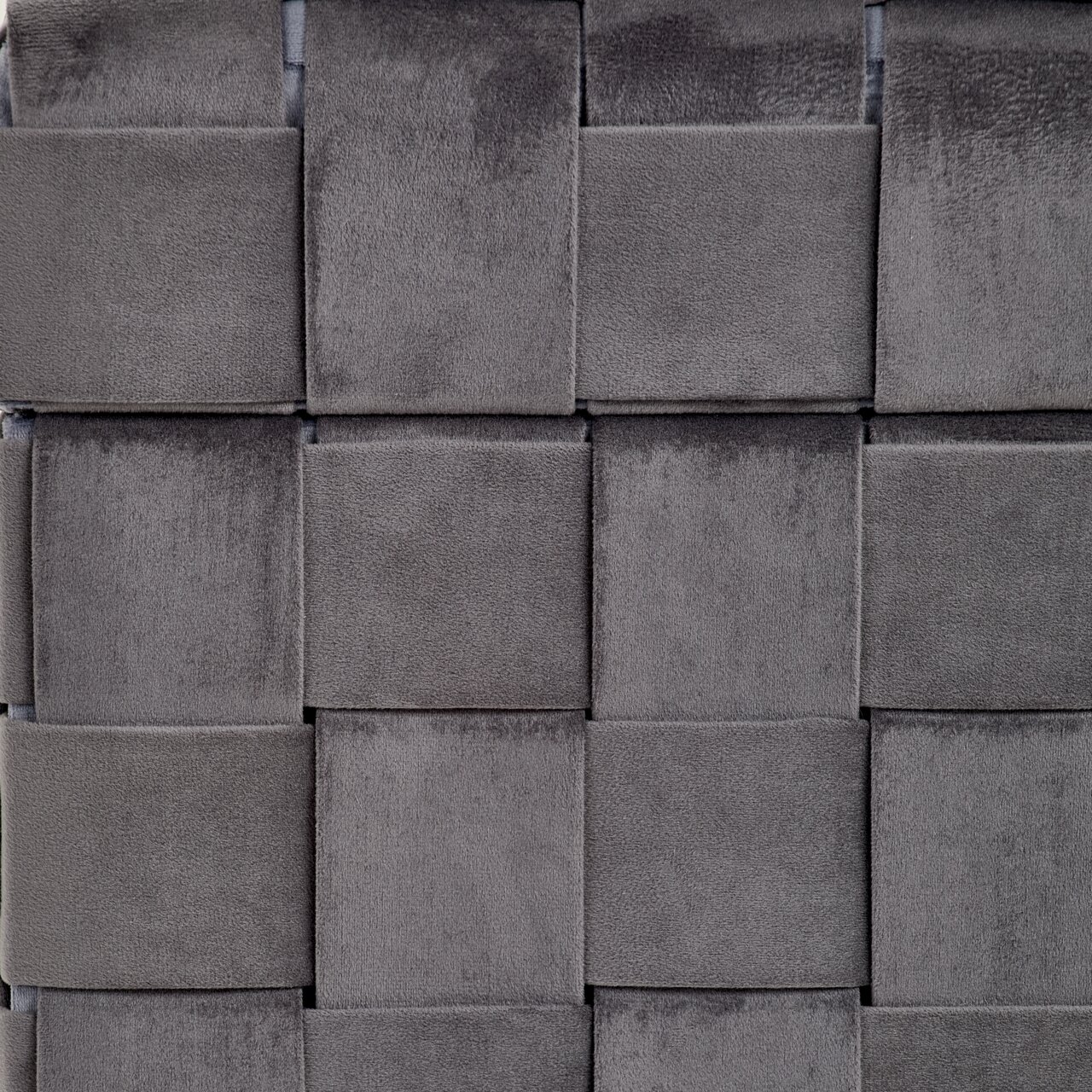 Nahaufnahme eines grauen, geflochtenen Stoffmusters eines Hockers mit Stauraum, von vorne betrachtet.