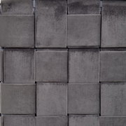 Nahaufnahme eines grauen, geflochtenen Stoffmusters eines Hockers mit Stauraum, von vorne betrachtet.