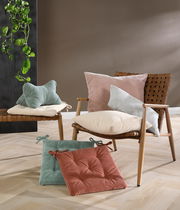 Sitzkissen in verschiedenen Farben auf einem Stuhl und Boden, seitliche Perspektive