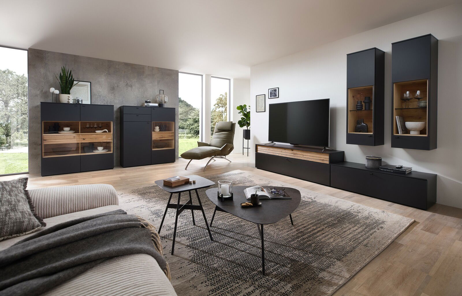 Venjakob Wandkombination LUMEA Moderne Wohnzimmerkombination Venjakob LUMEA mit dunklen Schränken, TV-Element und dekorativen Regalen, seitliche Perspektive.