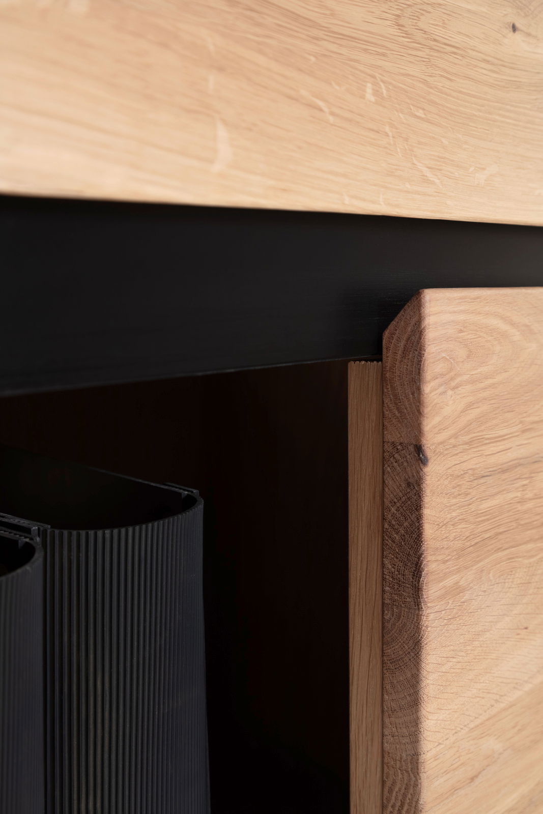 Nahaufnahme eines Holzregals mit schwarzem Akzent, seitliche Perspektive