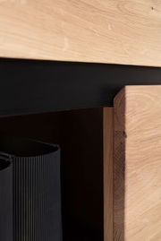Nahaufnahme eines Holzregals mit schwarzem Akzent, seitliche Perspektive