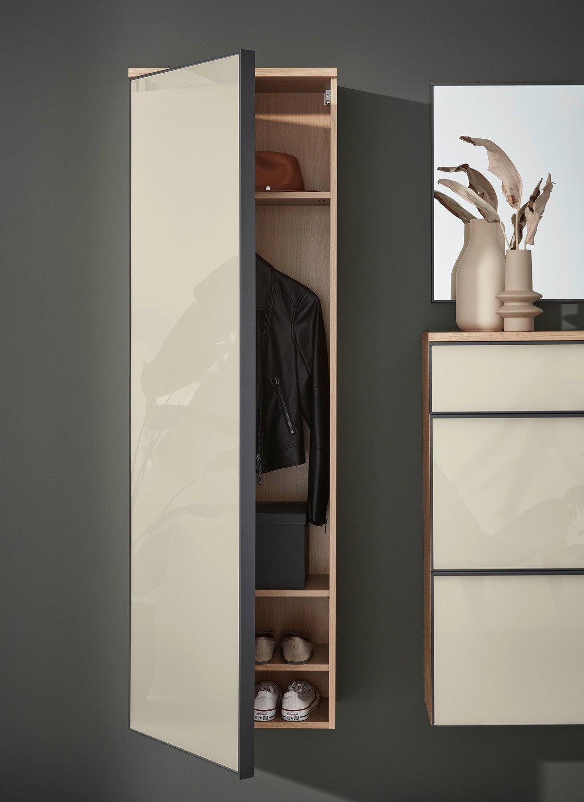 Hängender Garderobenschrank mit geöffneter Tür, zeigt Innenfächer mit Jacke, Hut und Schuhen, seitliche Perspektive
