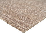 Beige-brauner Uni-Teppich in Nahaufnahme, perspektivisch von der Seite fotografiert.
