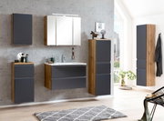 Moderne Badezimmermöbel in Holzoptik mit grauen Fronten, inklusive Hochschrank, aus seitlicher Perspektive fotografiert.