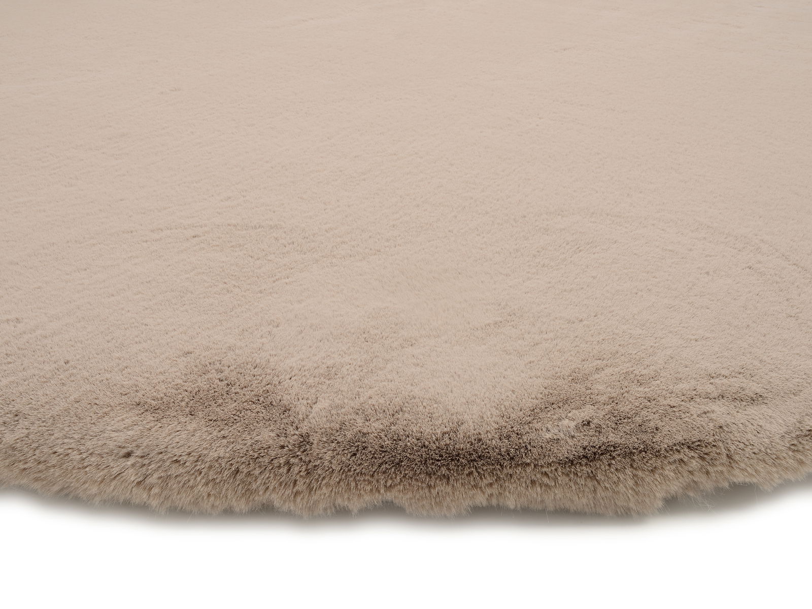 Nahaufnahme eines beigen Fellteppichs mit weicher Textur, von der Seite betrachtet.