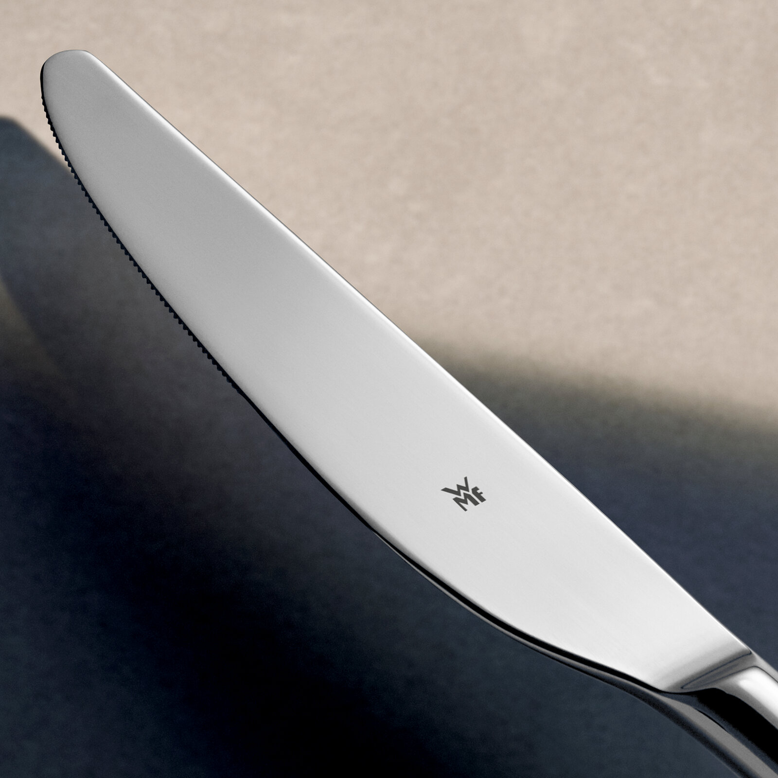 Nahaufnahme eines glänzenden Edelstahlmessers mit WMF-Logo, seitliche Perspektive