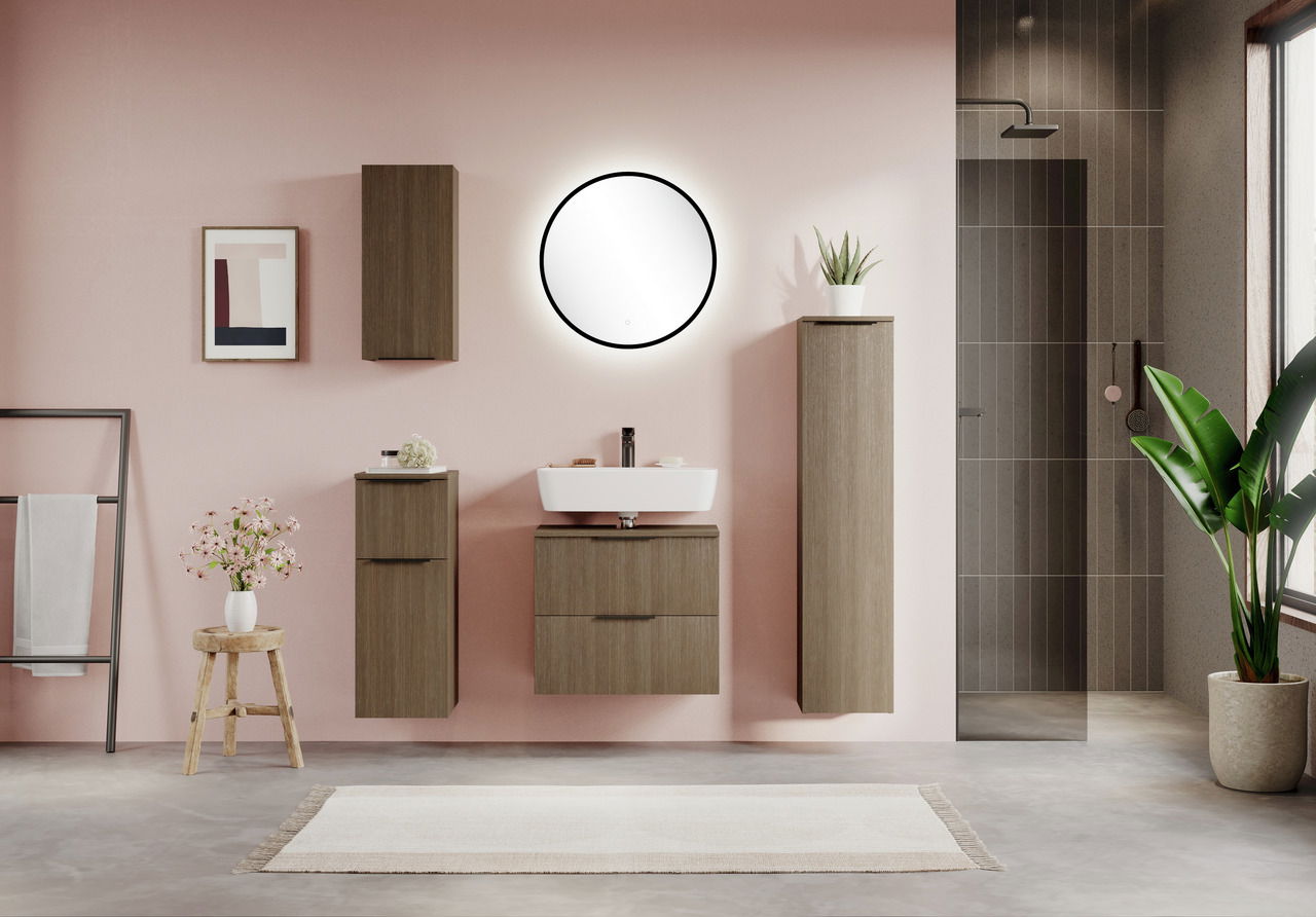 Runder Spiegel mit schwarzem Rahmen an einer rosa Wand, umgeben von modernen Badezimmermöbeln aus Holz, aus frontaler Perspektive.