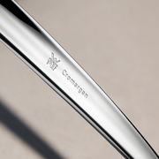 Nahaufnahme eines glänzenden Besteckteils aus Cromargan Edelstahl mit WMF-Logo, seitliche Perspektive.