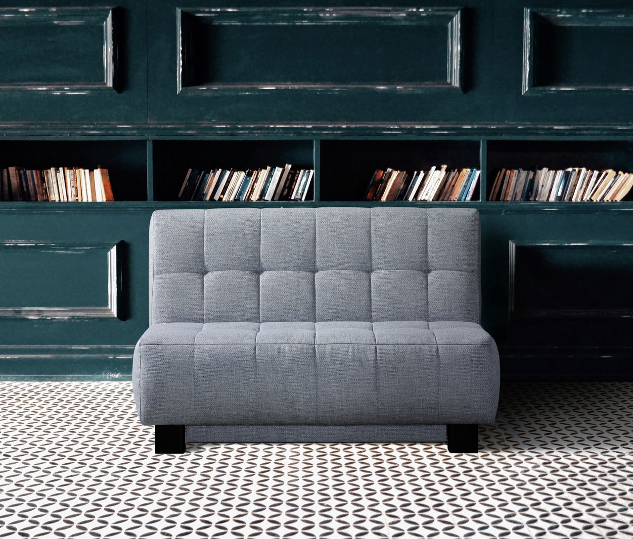 Novel Schlafsofa JUICE Graues Faltbett in einem stilvollen Raum mit Bücherregal im Hintergrund, Frontalansicht.