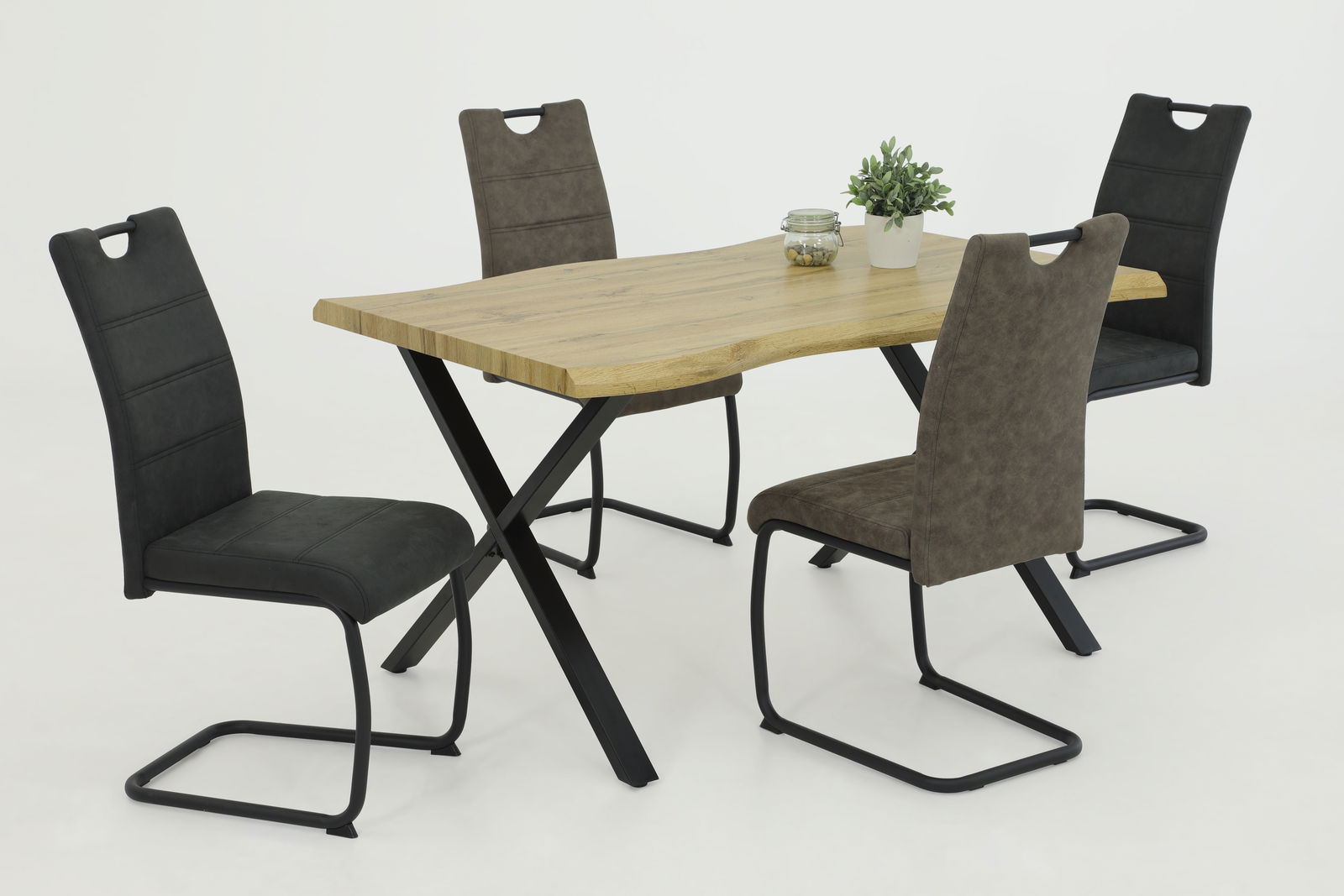 Esszimmer mit einem modernen Holztisch und vier Schwingstühlen in verschiedenen Farben, seitliche Perspektive.