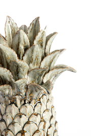 Nahaufnahme eines dekorativen Keramik-Ornaments in Form einer Ananas mit detaillierter Blattstruktur, seitliche Perspektive.