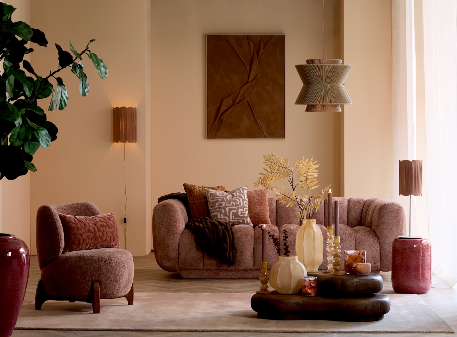 Frontalansicht eines stilvoll eingerichteten Wohnzimmers in warmen Erdtönen mit organisch geformtem Sofa und Sessel, dekorativen Kissen, tiefem Couchtisch, Vasen, Kerzen und harmonischer Beleuchtung.
