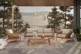 Loungegarnitur-Set auf einer Terrasse mit Blick auf einen bewaldeten Hang bei Sonnenuntergang, bestehend aus einem Sofa, zwei Sesseln und einem Couchtisch aus Holz, dekoriert mit Kissen und Kerzen.