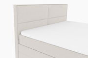 Boxspringbett in hellem Stoffbezug, seitliche Perspektive