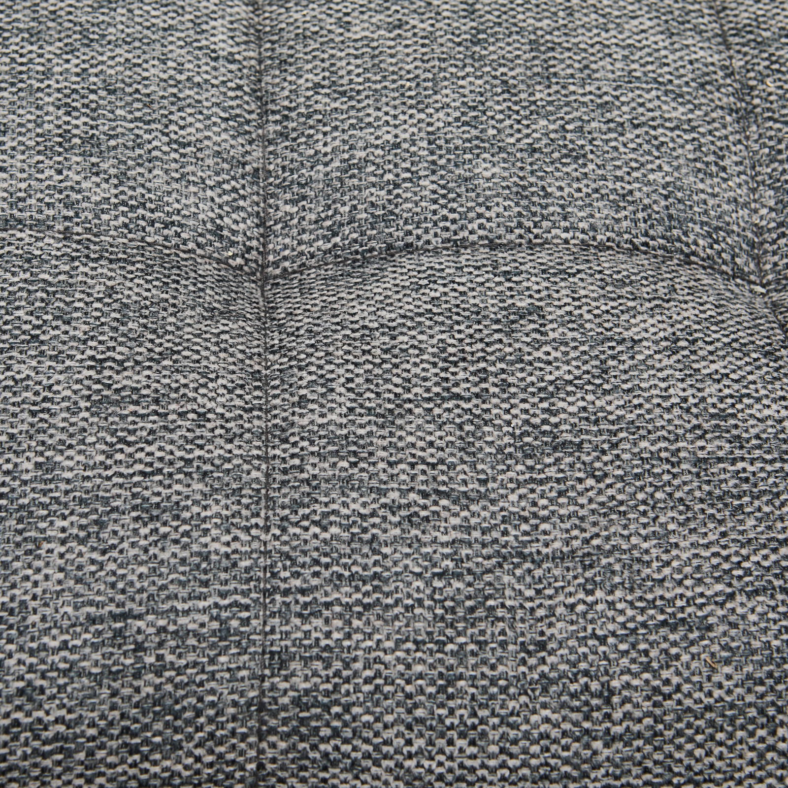 Nahaufnahme des grauen, strukturierten Stoffes einer Polsterbank von oben