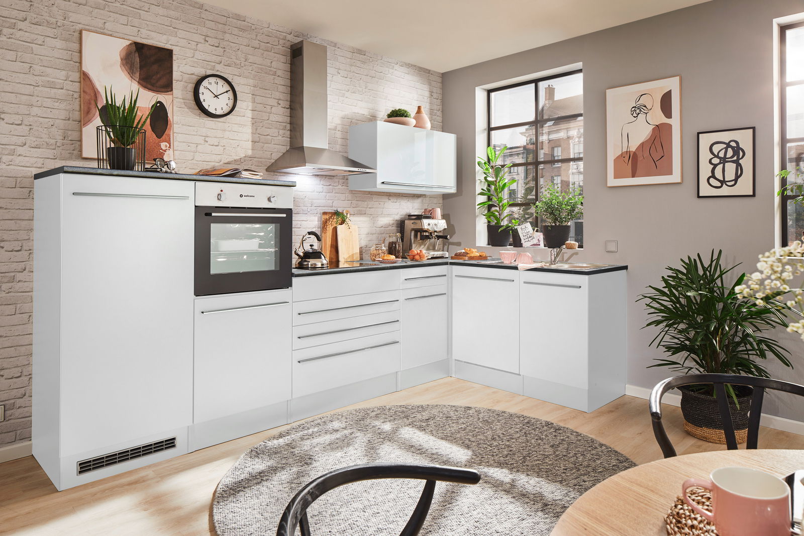 Moderne weiße Küche mit Eckunterschrank, Backofen und Dunstabzugshaube, aus der Perspektive eines gemütlichen Essbereichs mit Pflanzen und Kunst an den Wänden.