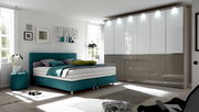 Moderner Funktionsdrehtürenschrank in einem stilvollen Schlafzimmer, Perspektive von vorne rechts