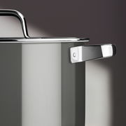 Nahaufnahme eines grauen Kochtopfs mit glänzendem Edelstahlgriff und Deckel, seitliche Perspektive.