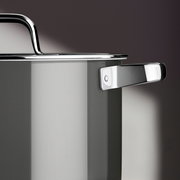 Nahaufnahme eines grauen Kochtopfs mit glänzendem Edelstahlgriff und Deckel, seitliche Perspektive.