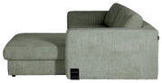 Zijaanzicht van een moderne lichtgroene corduroy hoekbank met brede chaise longue, zachte rugkussens en afgeronde vormen