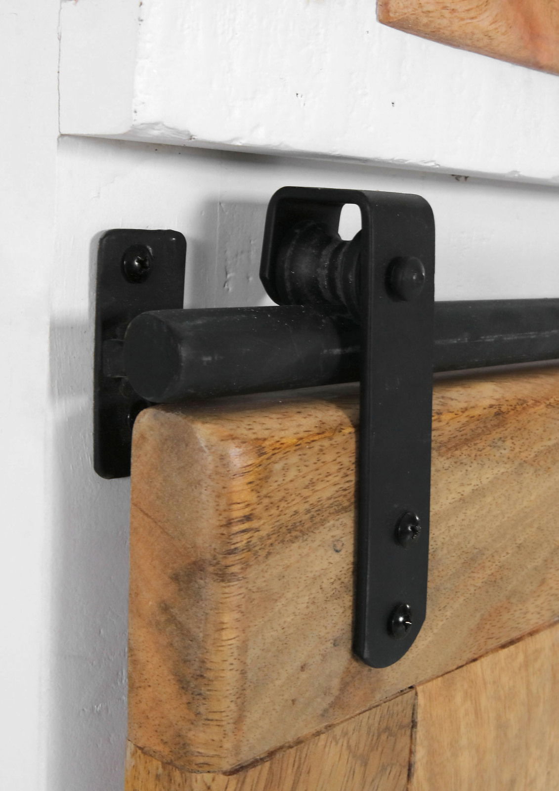 Nahaufnahme eines schwarzen Metallschiebers auf einer Holzplatte, Teil einer Vitrine, seitliche Perspektive.