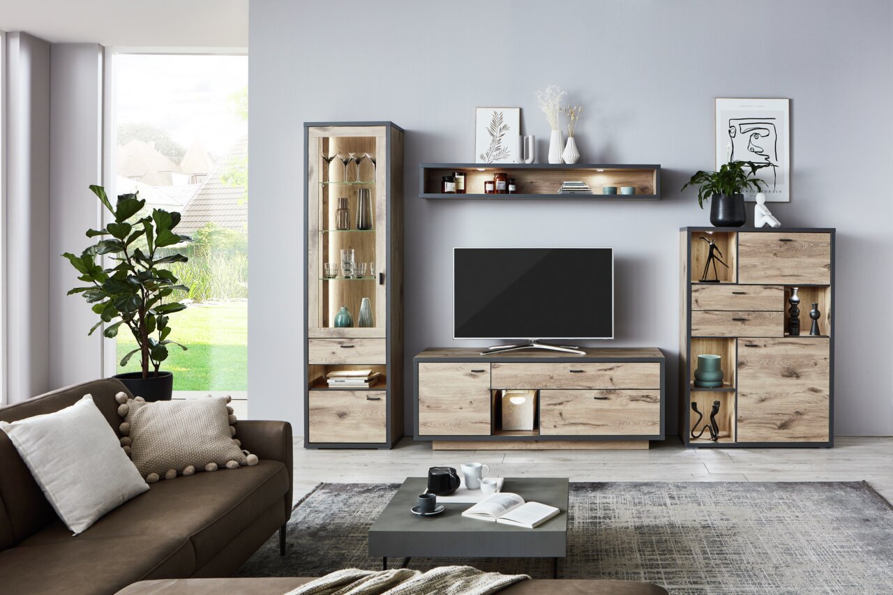 Moderne Wandkombination ORLANDO in Holzoptik mit TV-Schrank, Vitrine und Regalen, frontal fotografiert in einem stilvollen Wohnzimmer.
