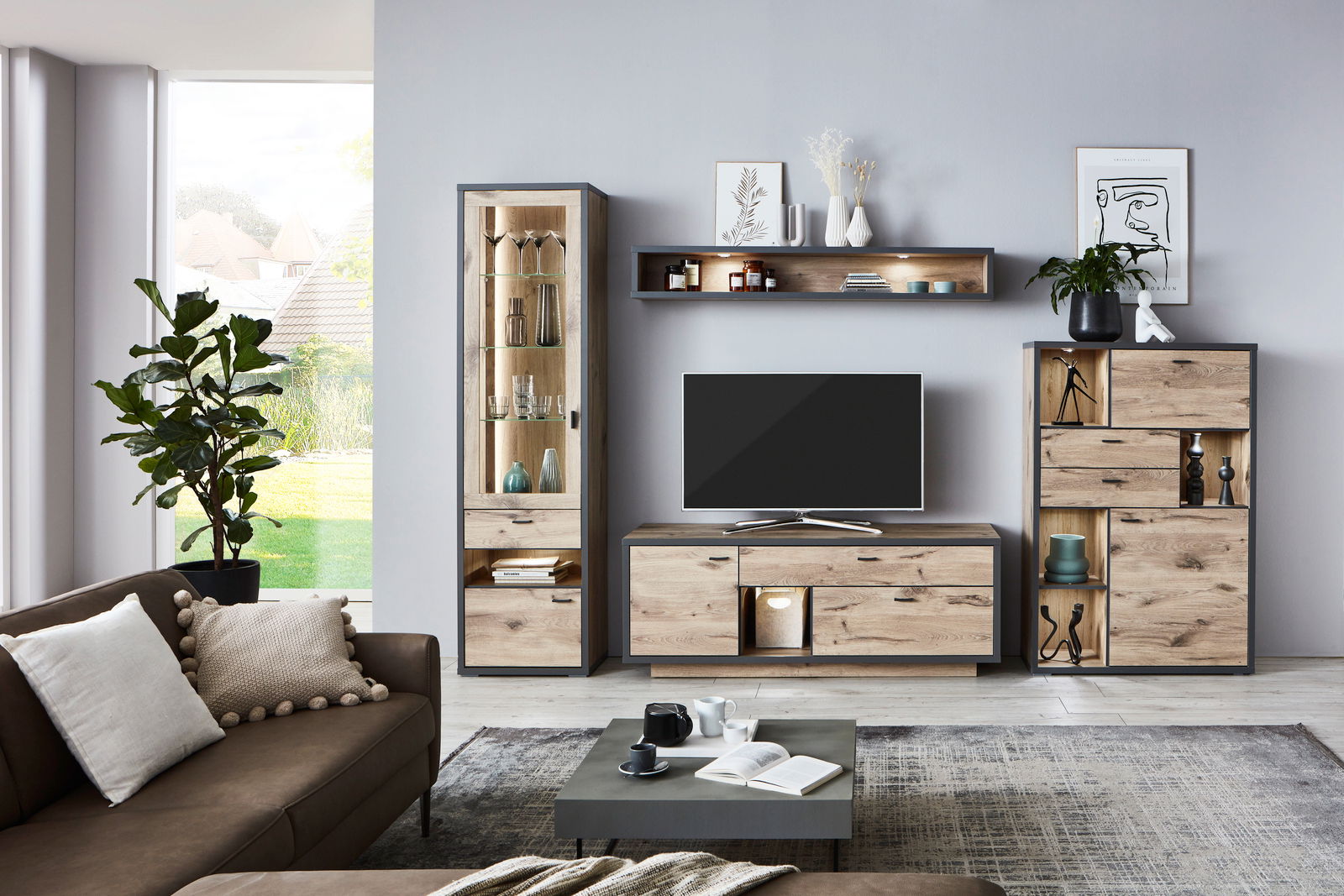 Moderne Wandkombination ORLANDO in Holzoptik mit TV-Schrank, Vitrine und Regalen, frontal fotografiert in einem stilvollen Wohnzimmer.