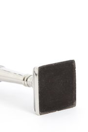 Nahaufnahme eines quadratischen Lampenfußes aus Nickel, liegend auf der Seite.