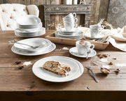 Ein stilvolles Kombiservice-Set mit 30 Teilen, präsentiert auf einem rustikalen Holztisch. Das Set umfasst Teller, Schalen und Tassen mit elegantem Design, ideal für festliche Anlässe. Perspektive: Draufsicht.