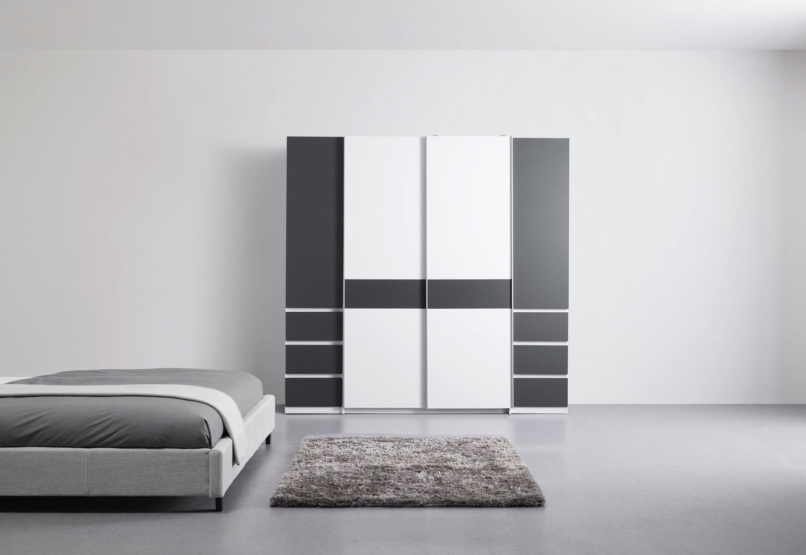 Moderner Dreh- und Schwebetürenschrank mit vier Türen in einer stilvollen Kombination aus Weiß und Dunkelgrau, frontal abgebildet in einem minimalistischen Schlafzimmer.